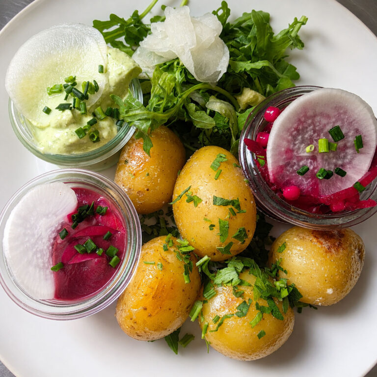 Herzhaft angerichteter Ginkgoteller mit kleinen Kartoffeln, frischem Blattsalat, Radieschen, eingelegtem Gemüse und cremigem Kräuterdip, garniert mit Schnittlauch und frischen Kräutern.